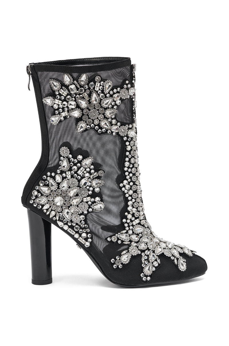 The AKIRA GOLD GRANDEUR BLACK EMBELLISHED COCKTAIL BOOTIE is a black mesh high heel bootie with silver rhinestone and crystal floral and geometric accents, finished with a back zipper.