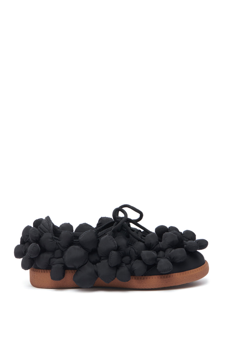 The AZALEA WANG GREYI BLACK PUFF FLORAL FLAT SNEAKER features playful round fabric puffs covering the upper, a black lace-up design, and a flat rubber sole for a bold and stylish look.