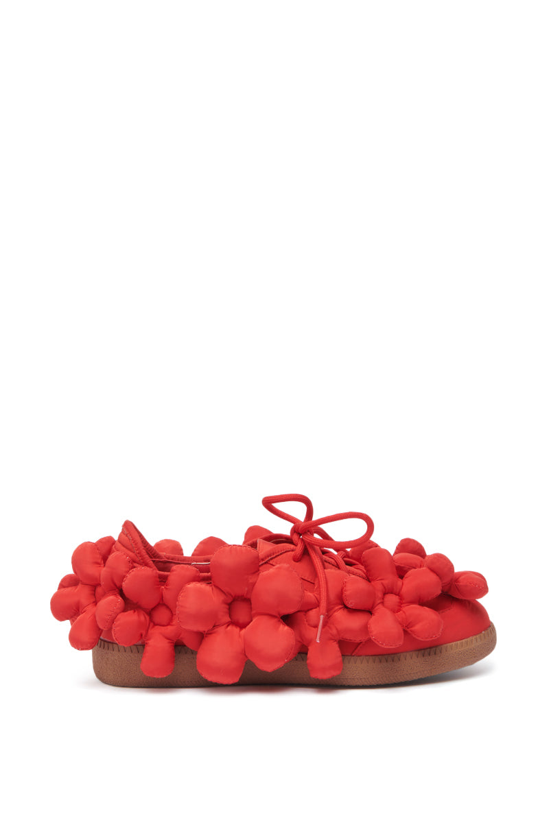 The AZALEA WANG GREYI RED PUFF FLORAL FLAT SNEAKER is a bright red flat sneaker with puffy floral appliques, red laces, and a brown sole, shown against a plain white background.