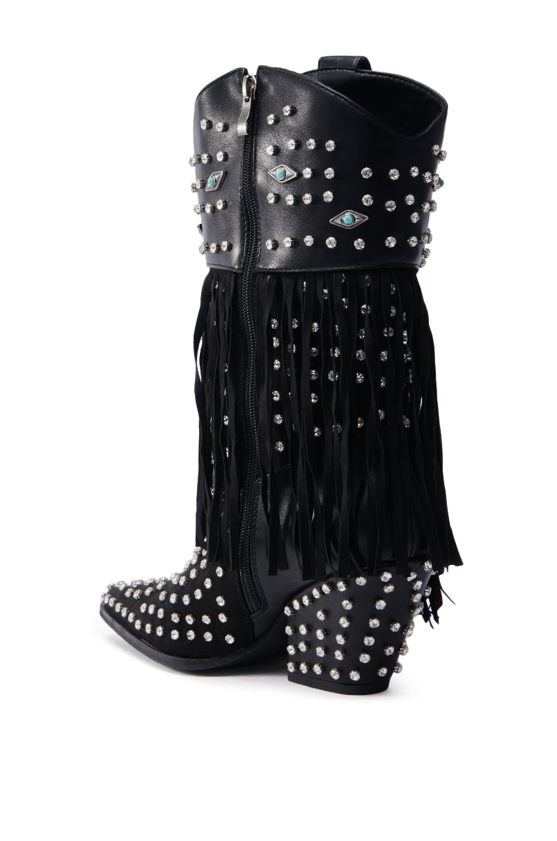 The AZALEA WANG GREYSON BLACK BOOTIE features black leather adorned with silver studs and eye designs. A long fringe cascades around the upper shaft, enhancing their cowboy charm. The chunky heel is studded at the heel and toe, ensuring a bold statement with every step.