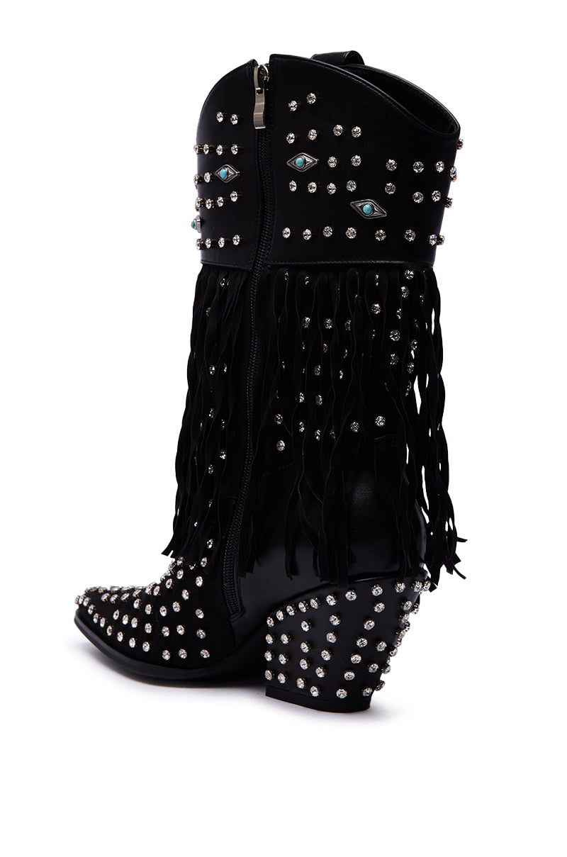 The AZALEA WANG GREYSON BLACK BOOTIE is a black faux suede western bootie featuring silver studs, side fringe, blue eye embroidery, a pointed toe, and a chunky studded heel.