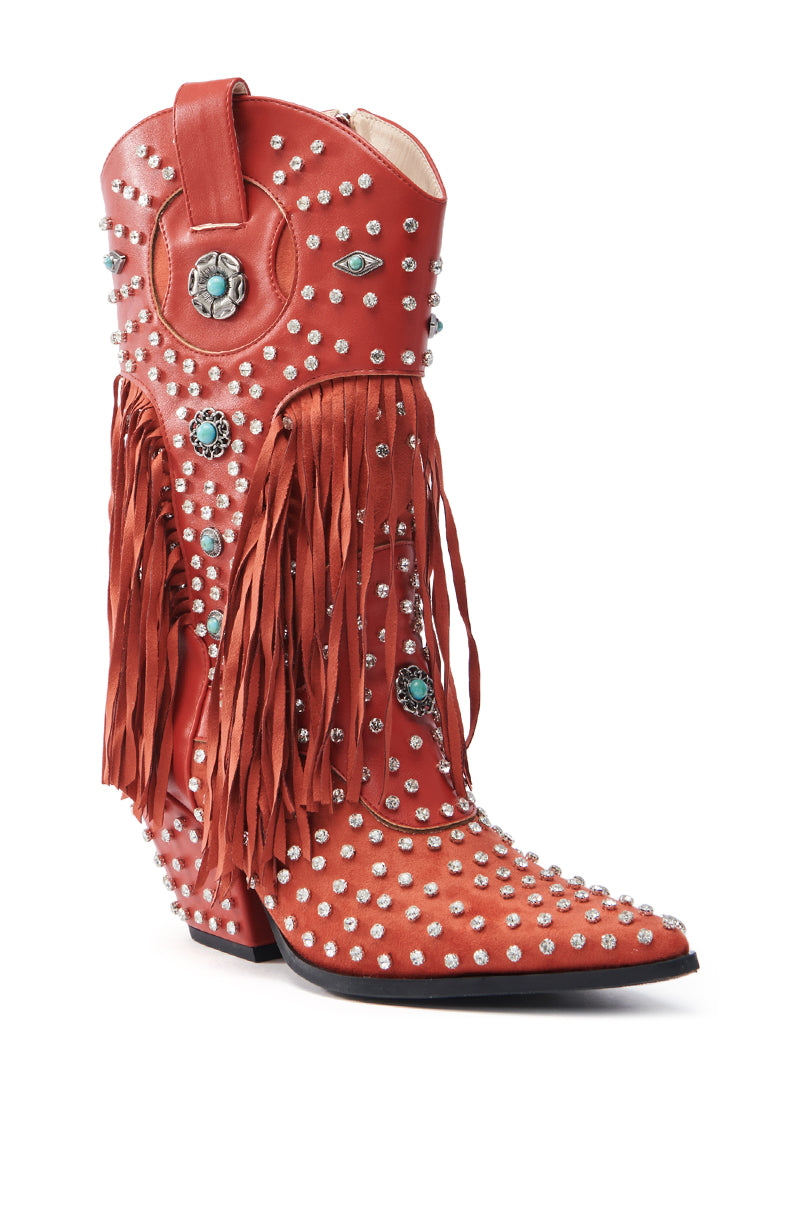 The AZALEA WANG GREYSON RED BOOT is a red faux suede cowboy boot beautifully decorated with silver studs, turquoise accents, side fringes, and circular details near the top. It features a pointed toe for a Western-inspired style.
