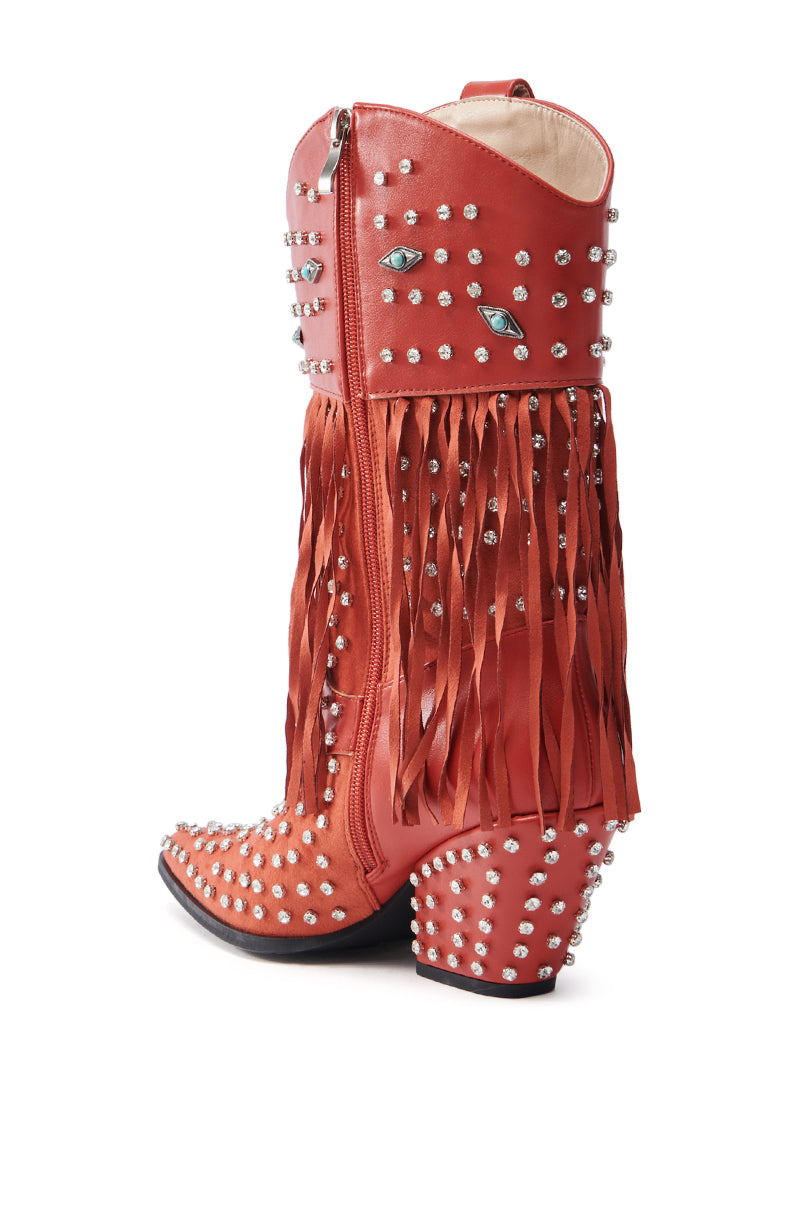 The AZALEA WANG GREYSON RED BOOT features a red cowboy design with silver studs, eye-shaped details, rhinestones, long red fringe, a chunky studded heel, and a visible side zipper.