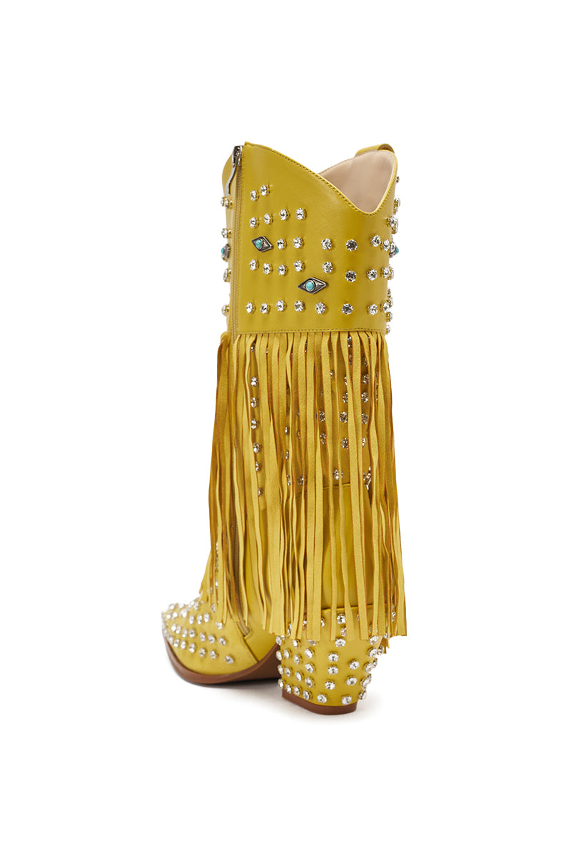 The AZALEA WANG GREYSON YELLOW RHINESTONE EMBELLISHED WESTERN BOOTIE features faux leather, silver rhinestone studs, long yellow fringe, a blue embroidered eye, and a mid-height heel.