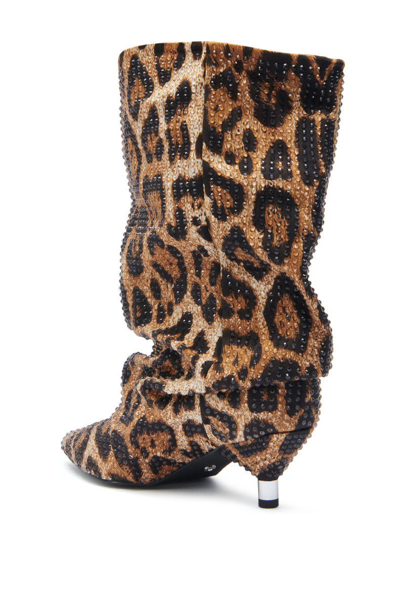 The AZALEA WANG GRIMES LEOPARD STILETO BOOTIE is a high-heeled, slouchy bootie with a pointed toe and bold brown and black leopard print, embellished with small rhinestones.