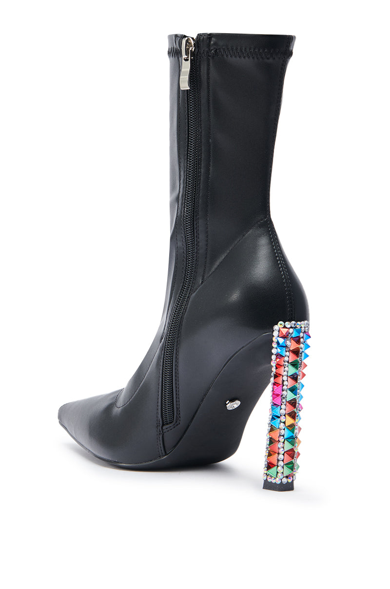 The AZALEA WANG GRYFFON BLACK STILETTO BOOTIE is a faux leather bootie with a pointed toe, side zipper, and chunky high heel accented by rainbow spike studs in a chic grid pattern.