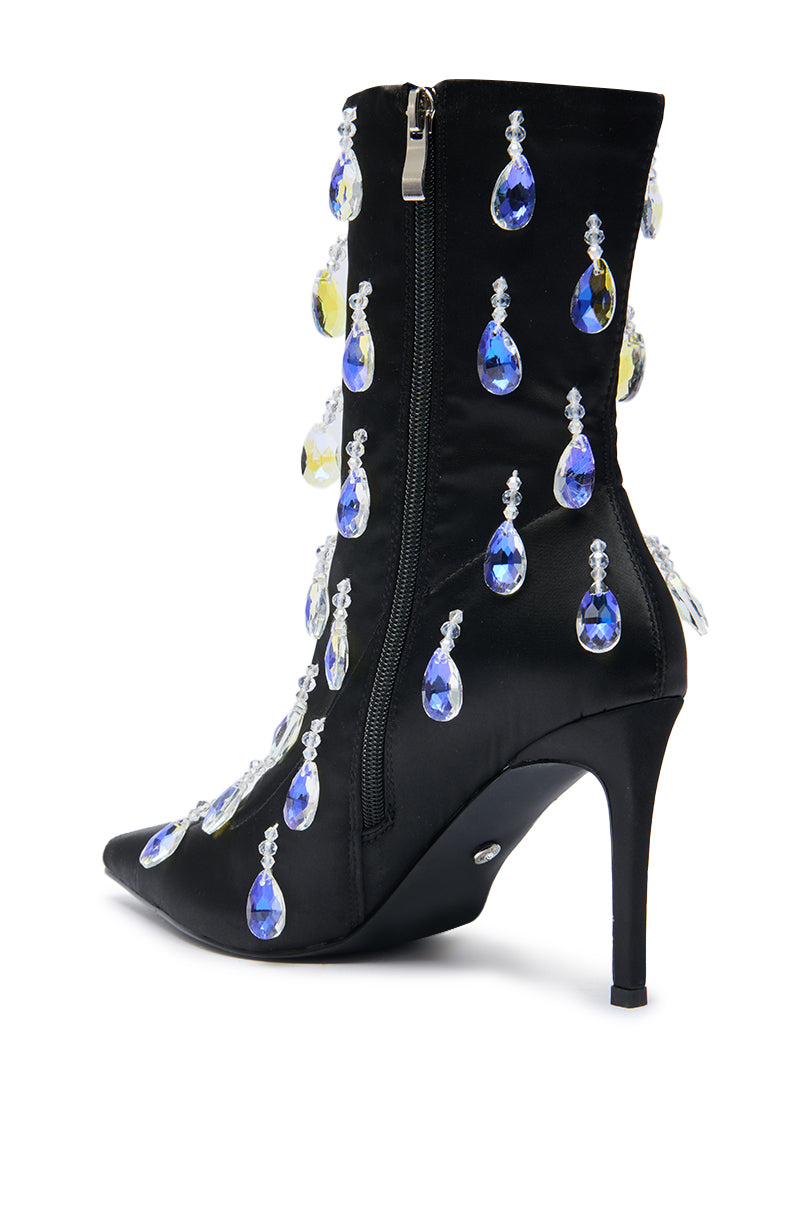 The AZALEA WANG GUANTLETT BLACK CRYSTAL EMBELLISHED BOOTIE is a black stiletto bootie with a side zipper, decorated with large blue and clear teardrop crystals for a glamorous look.