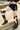 A woman pairs black shorts with the AZALEA WANG GWAYNE Black Multi Cow Western Boots.