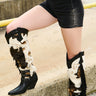 A woman pairs black shorts with the AZALEA WANG GWAYNE Black Multi Cow Western Boots.