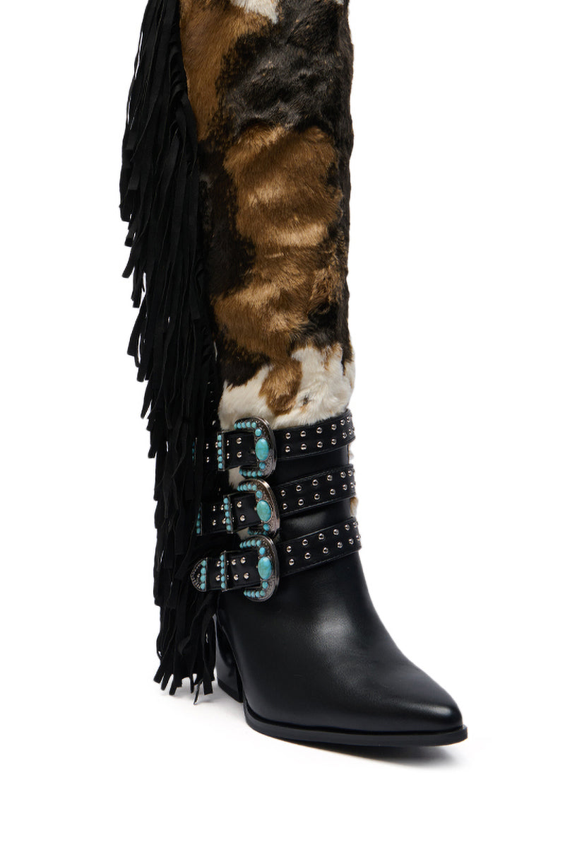 The AZALEA WANG GWAYNE BLACK MULTI COW WESTERN BOOT features a pointed black leather toe, black fringe, a brown and white fur shaft, and three decorative black straps with turquoise buckles and silver studs at the ankle.