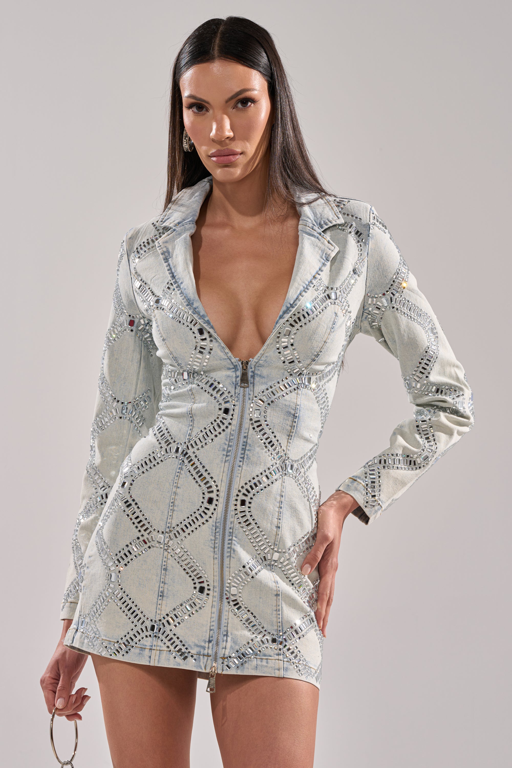 A woman wears the LOOK AT ME Rhinestone Blazer Dress in light blue denim, featuring a mini silhouette, long sleeves, deep V-neckline, cut-out details, and a front zipper, standing against a plain light background.