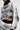 A person wearing the KALEIDOSCOPE DREAM PULL OVER SWEATER and matching pants in black and white. The cropped silhouette features abstract, dot-like designs, with black collar and cuffs. The focus is on the torso and upper legs against a plain background.