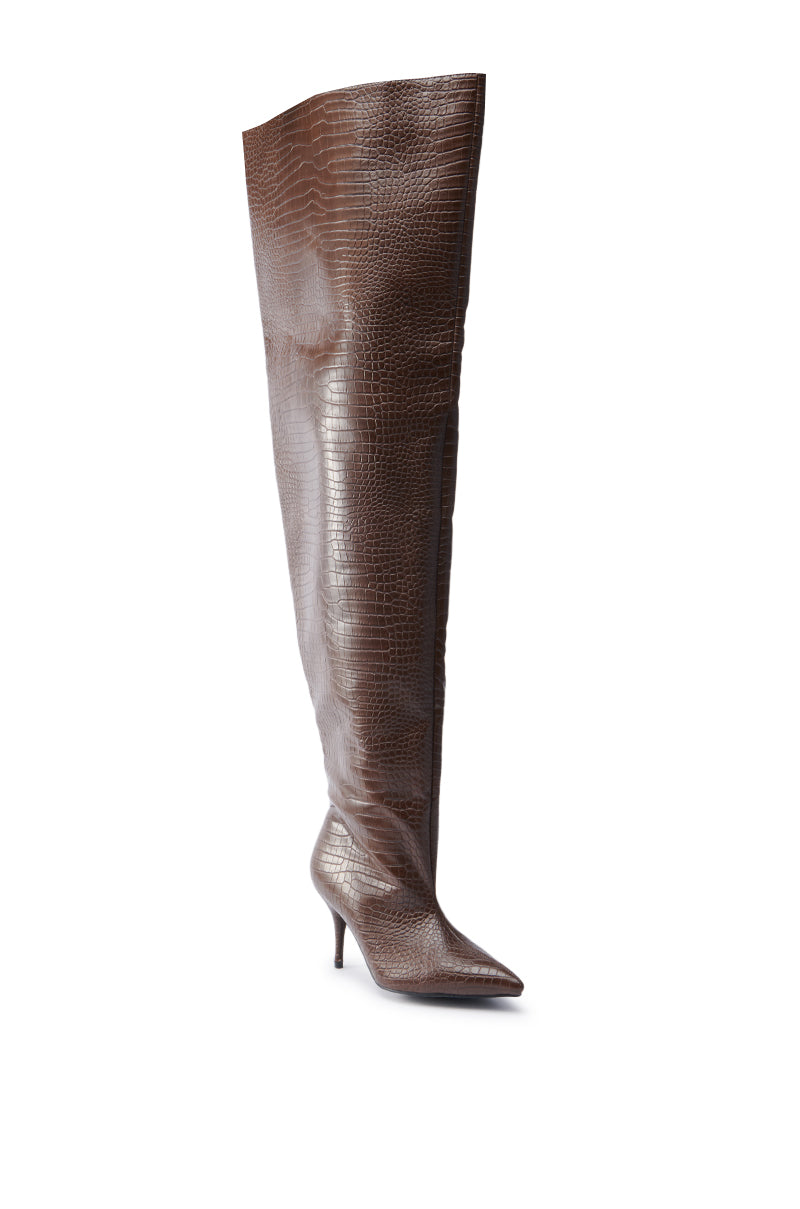 The AZALEA WANG HALINA BROWN CROC STILETTO BOOT is a knee-high, pointed-toe boot with a low heel, featuring a faux crocodile leather pattern. It is displayed on a white background to emphasize its elegant design.