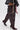 Wearing the AZALEA WANG HALINA BURGUNDY CROC STILETTO BOOT with a thigh-high faux crocodile shaft, this look pairs the shiny boots with a black and white skirt featuring colorful, patterned fabric strips.