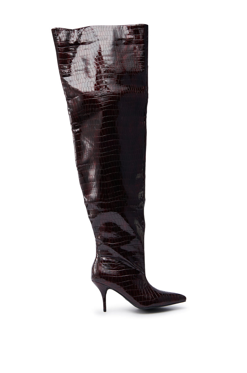 The AZALEA WANG HALINA BURGUNDY CROC STILETTO BOOT features a tall, pointed toe design with a thigh-high shaft and dark glossy burgundy croc texture for a dramatic look.