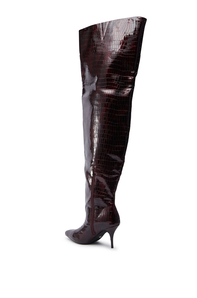 The AZALEA WANG HALINA BURGUNDY CROC STILETTO BOOT features shiny faux crocodile leather, a pointed toe, thigh-high shaft, and side zipper.