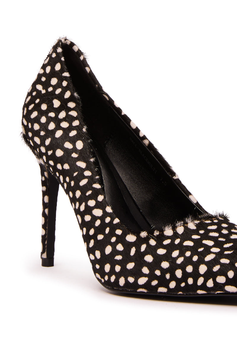 The AZALEA WANG HALL Black Multi Spotted Pony Hair Pump features a pointed toe, stiletto heel, black pony hair with a white polka dot pattern, and a textured, slightly furry finish.