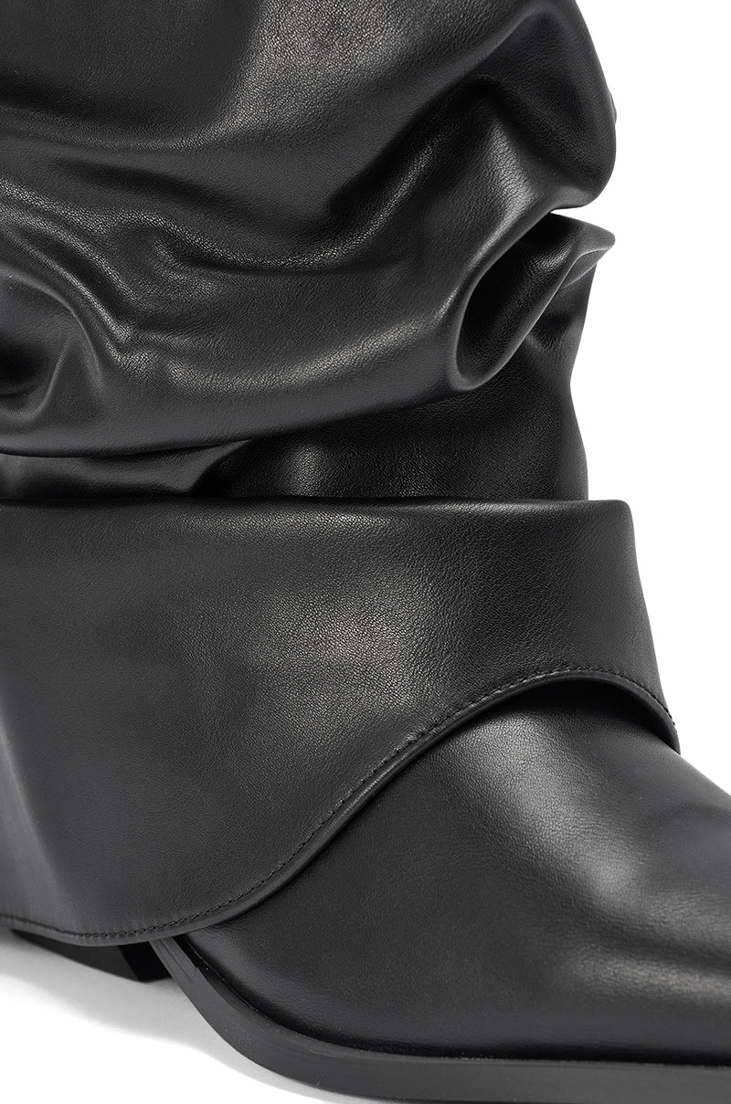 The AZALEA WANG HAWKSTON BLACK PU RUCHED WESTERN BOOTIE features a slouchy, layered shaft, pointed toe, and black faux leather finish for a modern take on the classic western silhouette.