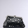 The MIRROR MIRROR CLUTCH is a black faux leather handbag adorned with a silver clasp and an array of metallic studs in various sizes, scattered artfully for a chic and contemporary look. It includes a silver chain link shoulder strap and stands out against a plain, light grey background that accentuates its detailed design.