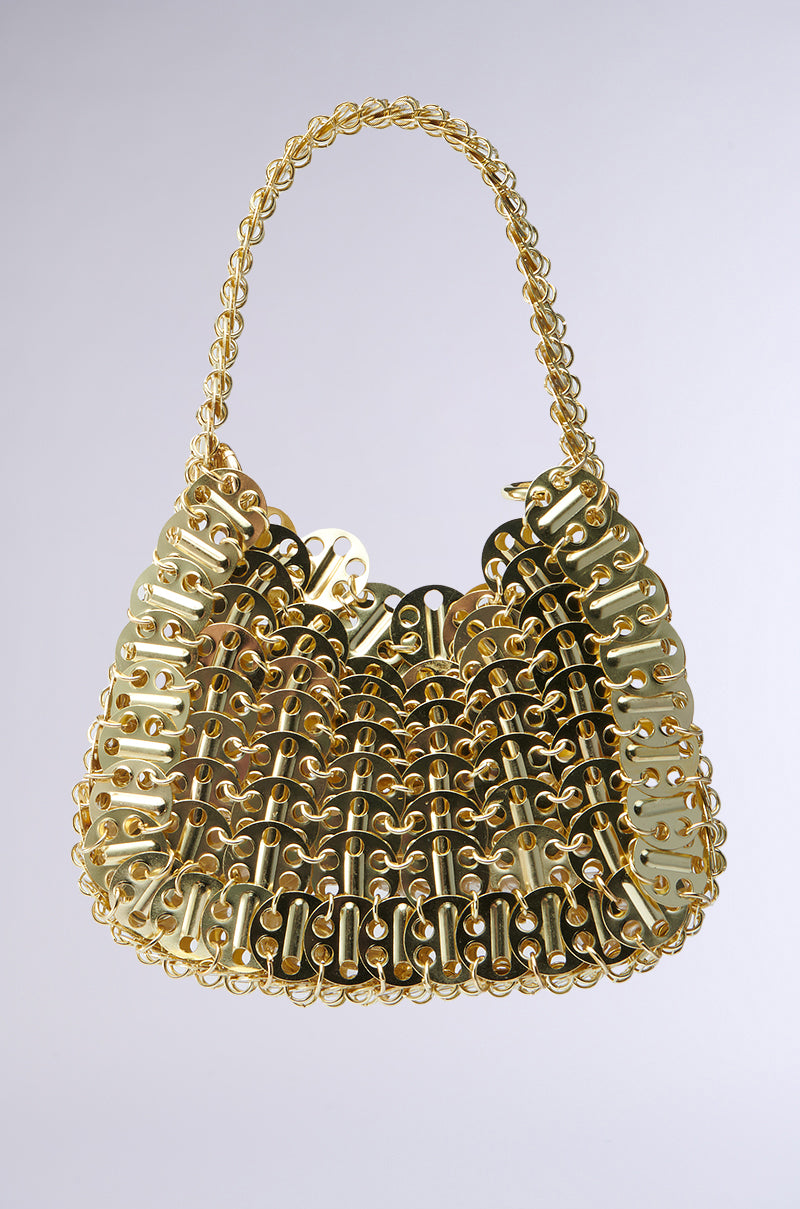 The TAYTAY METAL PURSE is a fashion accessory made from interlinked faux gold chain-like pieces, forming a textured lattice. It comes with a matching chain link shoulder strap, offering an elegant and cohesive design against any plain background. 7