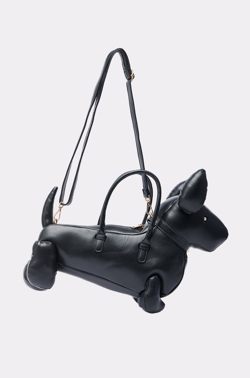 The BARK BACK PU DOG PURSE is a black faux leather bag shaped like a dog, with gold hardware, pointed ears, tail, two handles, a long adjustable strap, and a decorative collar for extra charm.