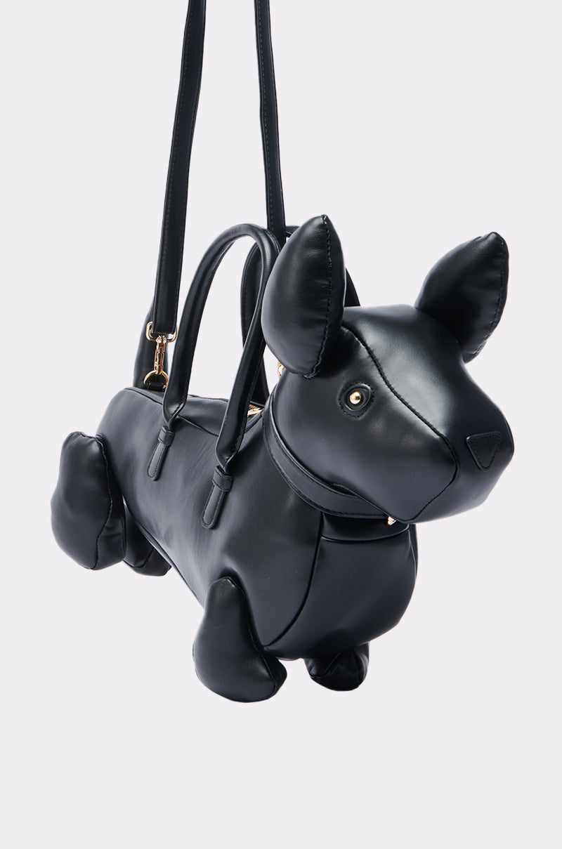 The BARK BACK PU DOG PURSE is a black, dog-shaped faux leather handbag with upright ears, gold hardware, two handles, and a shoulder strap—perfect for dog lovers. Displayed against a plain white background.