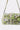 The IM OUT HERE BLING PURSE is a rectangular bag with a flap closure and shoulder strap, crafted in lime green brocade and embellished with metallic studs and multicolor gemstones.