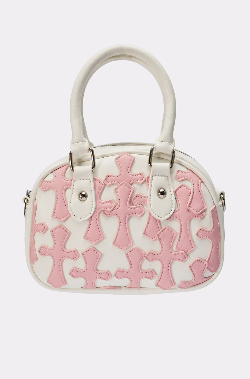 The ELLE CROSS PURSE is a small white faux leather handbag with dual handles, silver hardware, and a modern design. It features multiple light pink cross appliqués on the front for a stylish touch. 0