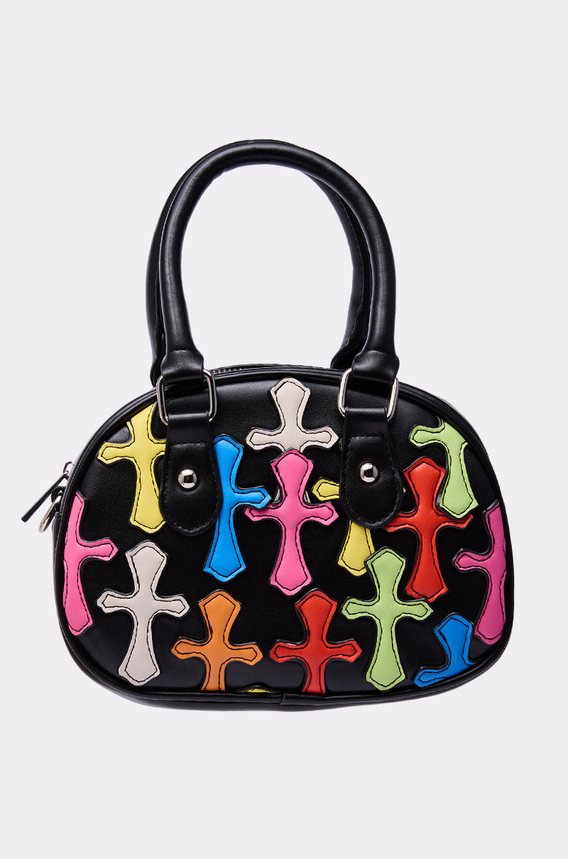The CROSS ME PATCH PURSE is a black handbag with two handles, featuring colorful cross-shaped patches in pink, blue, green, yellow, red, orange, and white adorning the front. 0