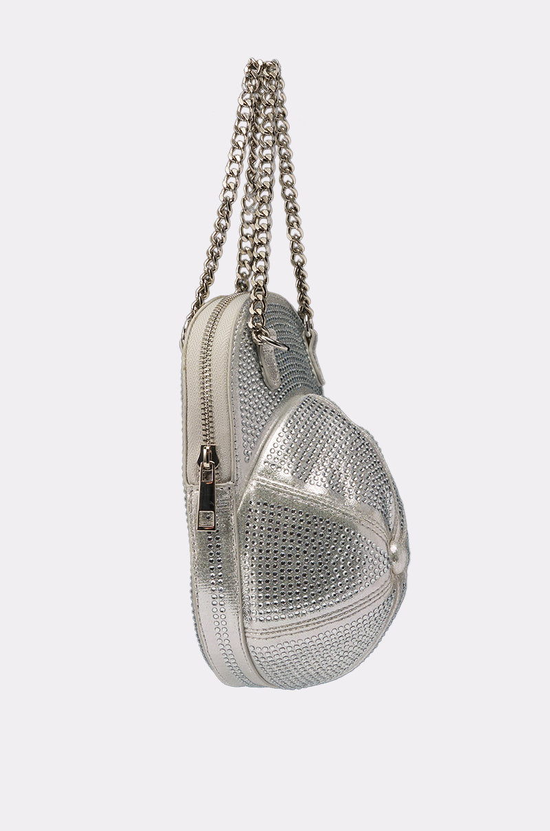 The NO CAP BLING PURSE is a metallic silver, baseball cap-shaped handbag with a studded texture, zipper closure, and two silver chain handles—this eye-catching purse pops against a plain light background. 2