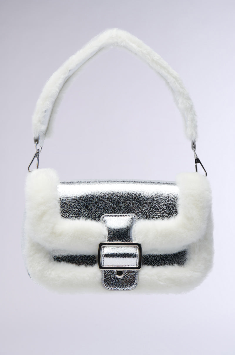 Presenting the NEVER THE PICK ME FUR TRIM PURSE, this stylish handbag features a silver metallic texture with luxe faux fur trim. Its rectangular design is complemented by a central strap and metallic buckle, while the matching handle enhances its charm against the simple, neutral gradient background.