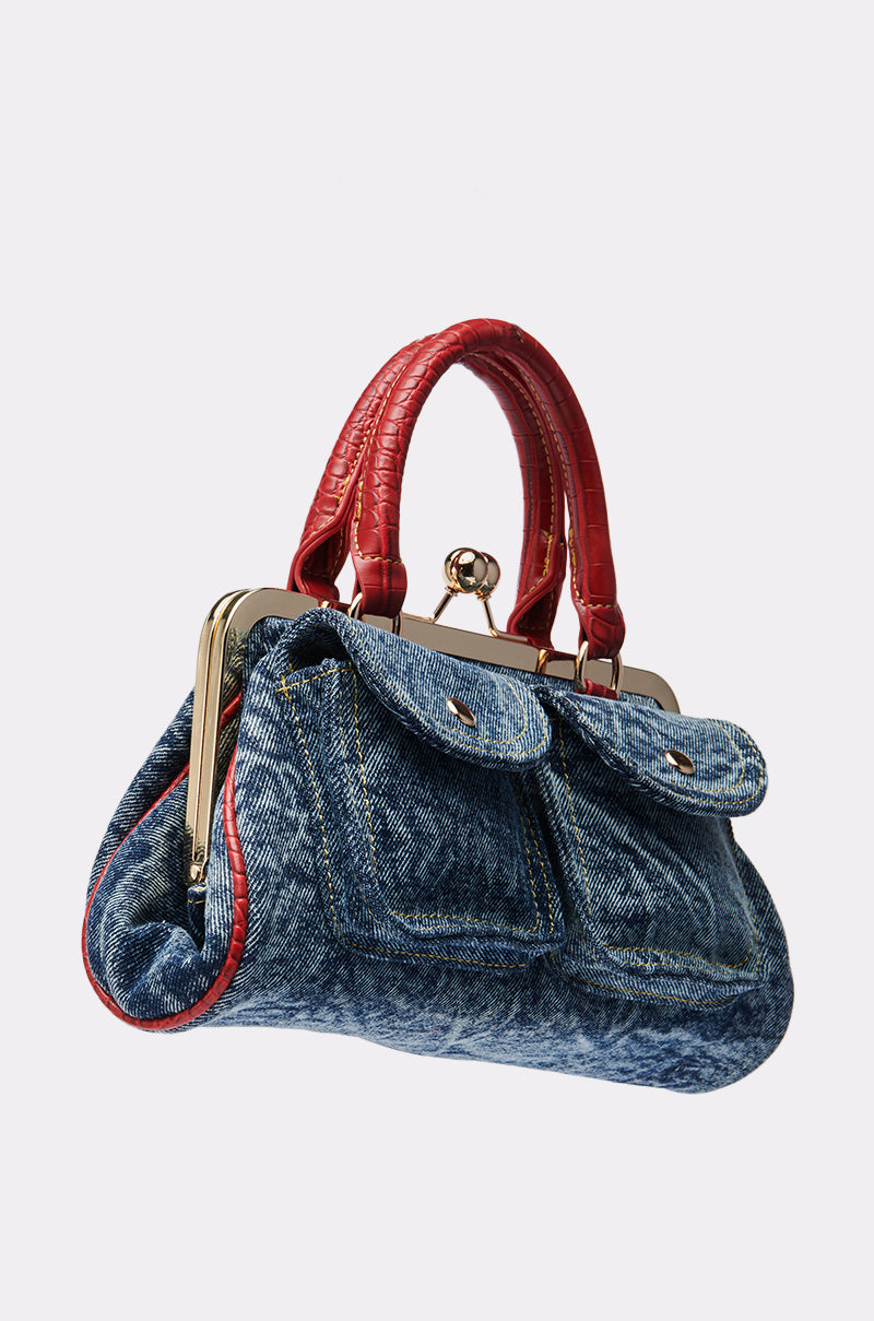 The ON THE FLIGHT CARGO COIN PURSE is crafted from blue denim, features two front cargo pockets, red faux crocodile textured handles, gold-tone hardware, and a vintage-style clasp closure.
