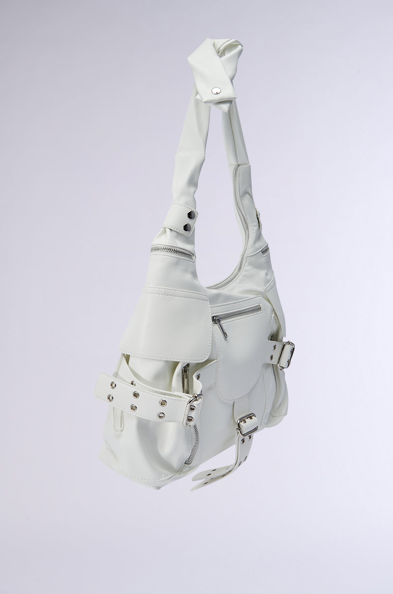Presenting the R U WITH IT BAG, a chic faux leather handbag featuring an oversized silhouette, multiple pockets, and silver buckles. Its elegant and modern style is accentuated by a unique twisted handle design against a plain gray background. 2