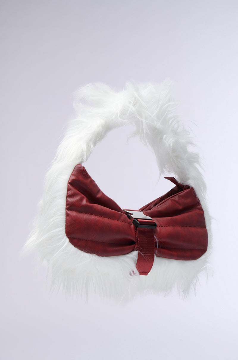 The OVERZEALOUS FUR TRIM PURSE from the AKIRA Label is elegantly displayed against a plain background, showcasing its striking red design with a fluffy white faux fur strap and trim. This chic handbag features a sleek buckle closure at the center, exuding sophistication.