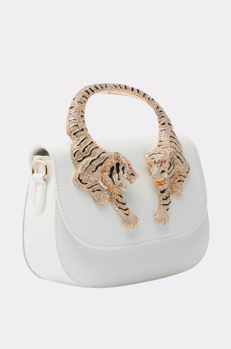 The LUXE LIFE PURSE is a white handbag with a sculpted gold handle featuring two jeweled tigers facing each other above the flap closure. 2