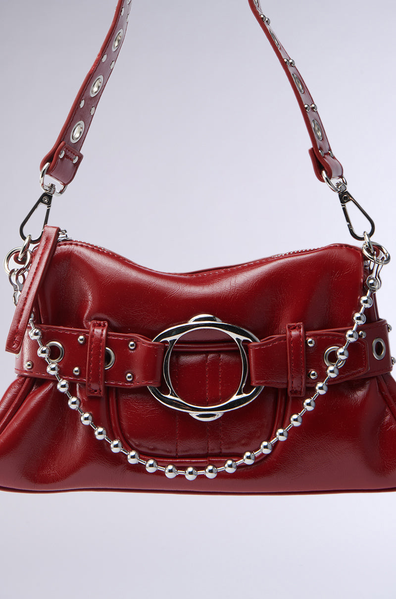 The RED HOT PU BAG is a small, shiny red faux leather purse with a decorative silver buckle, belt detail, beaded silver chain, and a sturdy strap featuring metal eyelets and clasps for a chic, structured look.