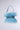 The WORTH IT ALL FEATHER PURSE is a chic accessory adorned with soft, light blue feathers and rhinestone accents on a shimmering strap. With two handles, it stands elegantly against a plain, light backdrop.