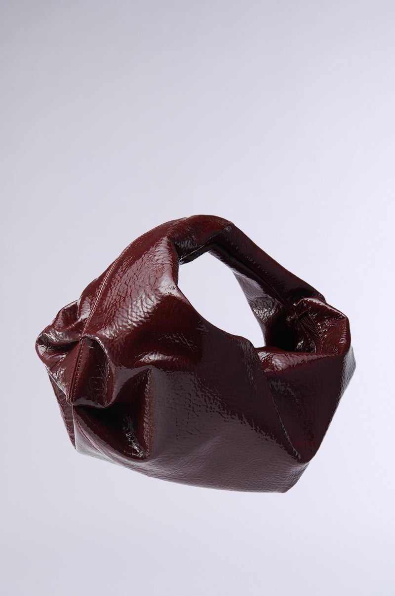 The LEATHER LOVIN' PU PURSE in burgundy, with its chic crumpled faux leather and flexible handle, floats against a light gray background. 2