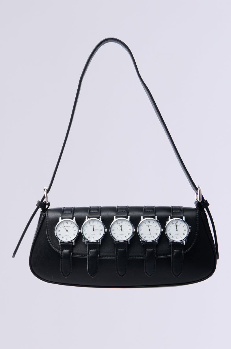 The WATCH YA SELF PURSE is a black, vegan leather shoulder bag with a short strap, adorned with five wristwatch embellishments featuring round faces, white dials, and silver bezels on the front for a unique and stylish look.