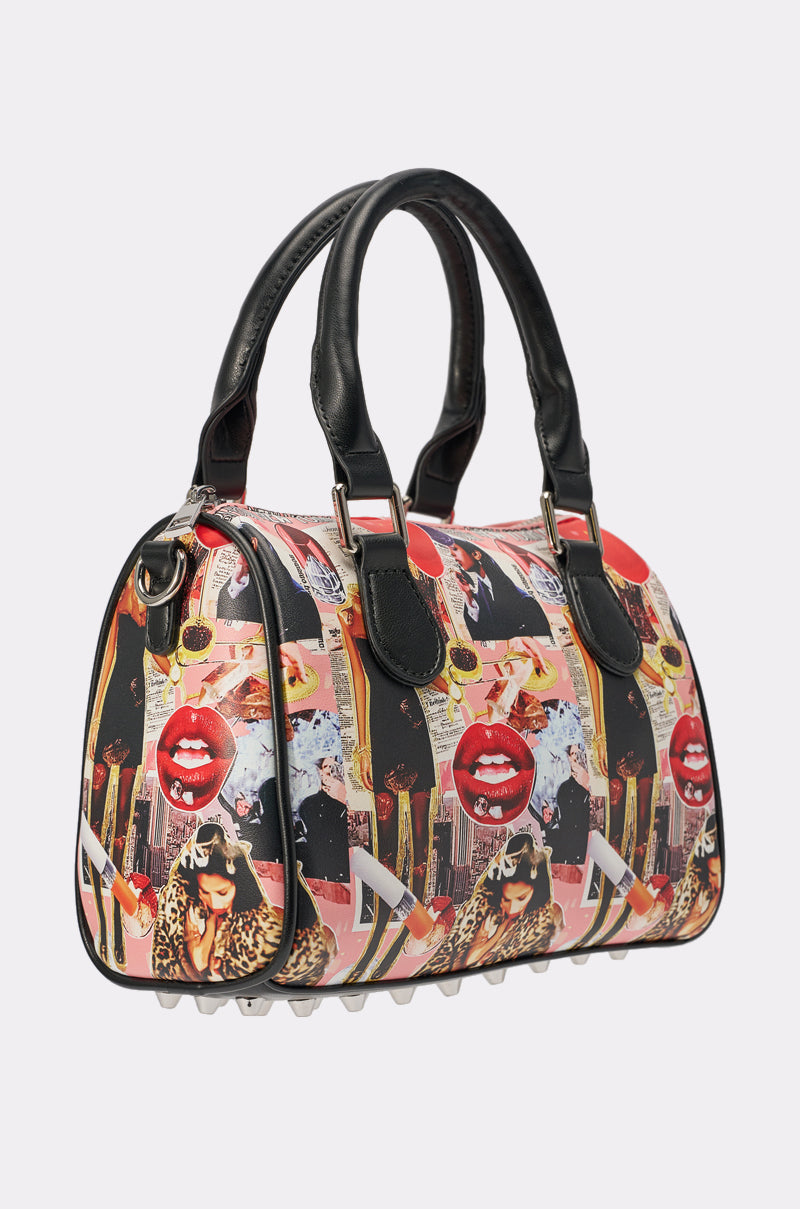 The IN THE ZINE PURSE features a vibrant pop art collage with red lips, faces, lipstick, and abstract patterns on a colorful design with black handles—ideal for street style accessory lovers. 2
