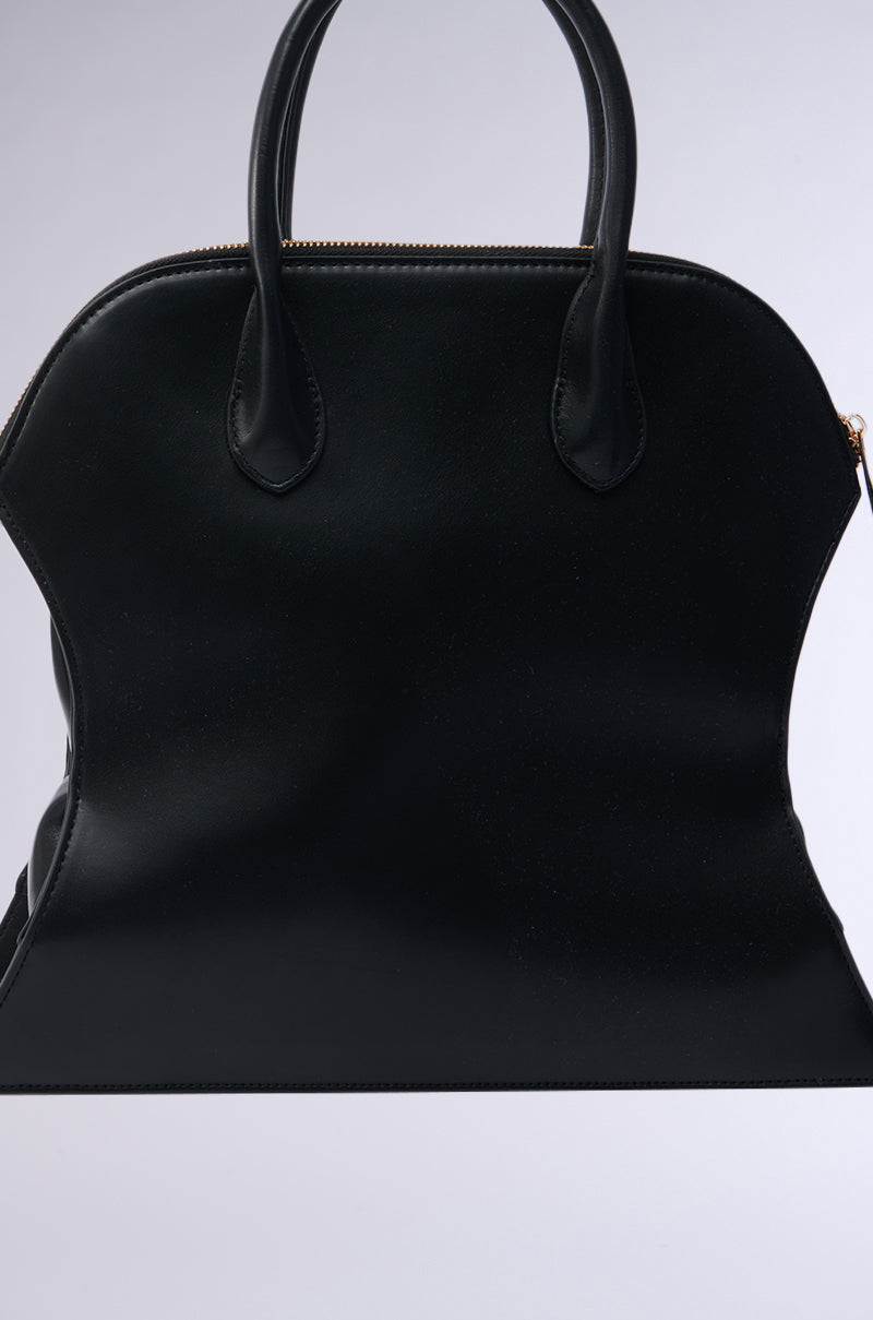 A modern accessory, the YOU NOT USED TO THIS PURSE is a black faux leather handbag with two handles and a gold zipper. It features a structured silhouette, smooth surfaces, and minimal embellishments against a light gray background. 3