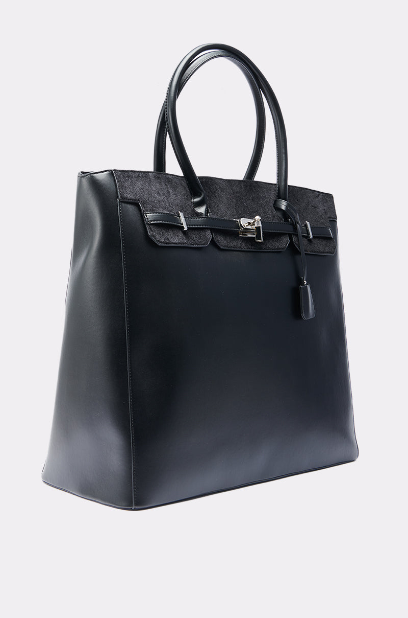 The FEEL ME OVERSIZED TOTE is a large, structured faux leather handbag with two handles, a flap closure, silver hardware, and lock-and-key detail, shown against a plain light background.
