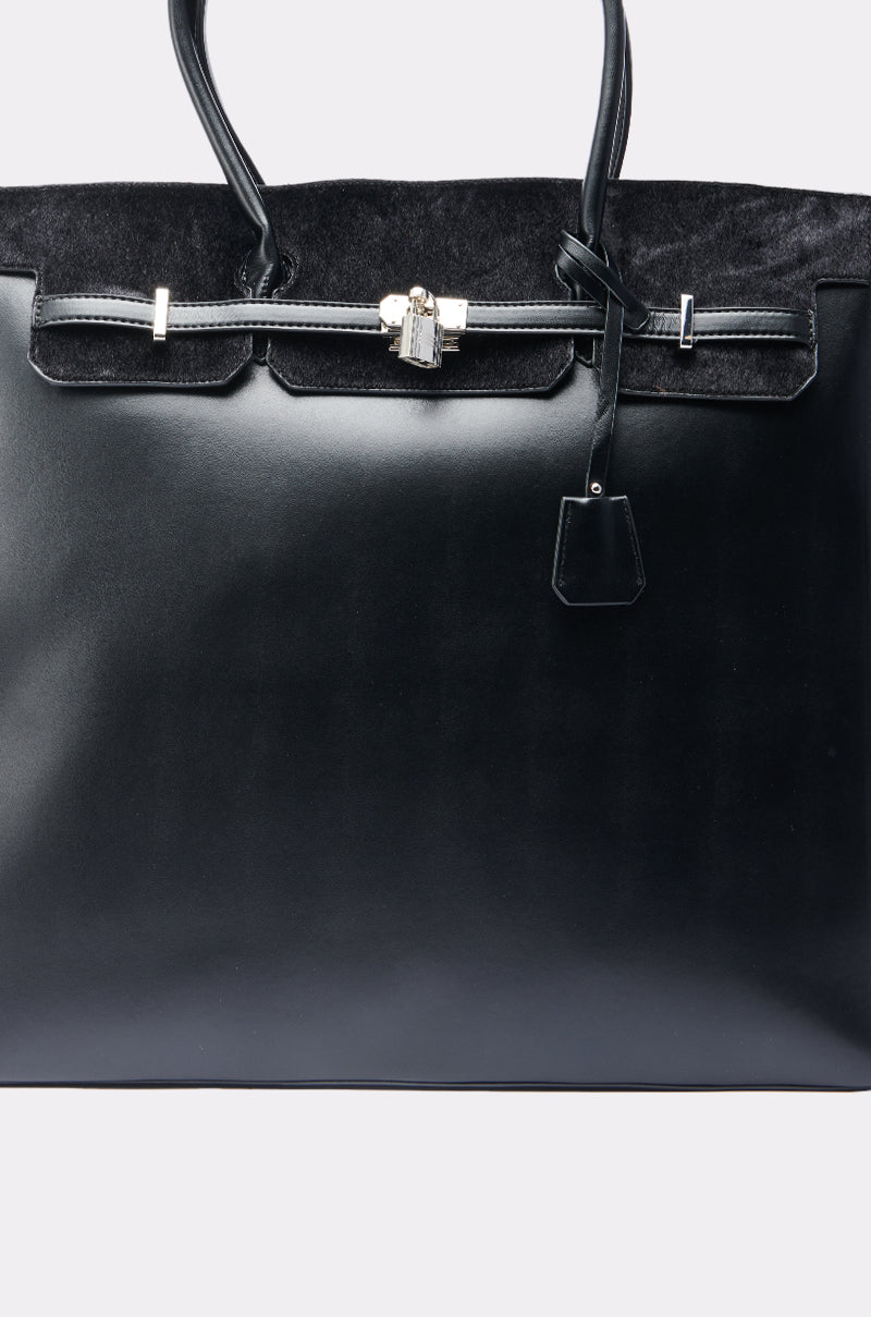 A close-up of the FEEL ME OVERSIZED TOTE, a faux leather handbag with silver hardware, top handle, small padlock, metallic zip-top closure, and soft suede upper section.