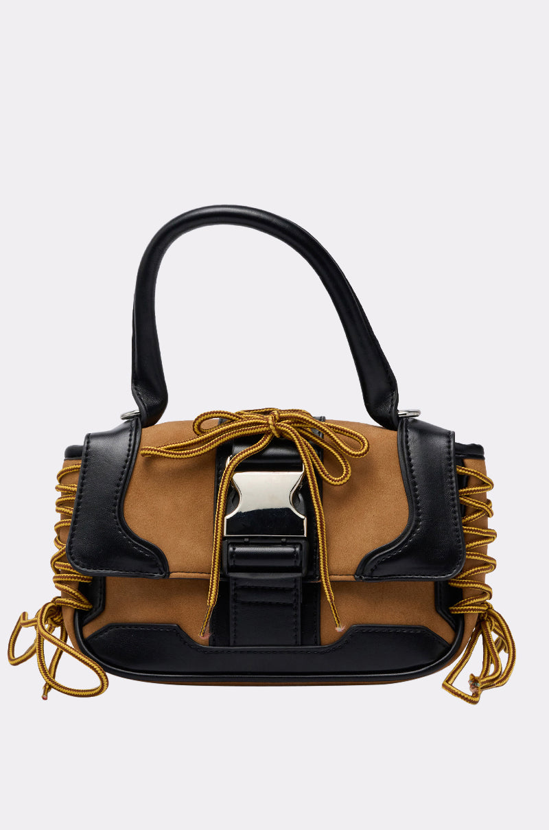 The IN THE STREETS PURSE is a trendy bag with black handles and trim, tan suede panels, gold rope accents on the sides and front, a crossbody strap for versatility, and a large silver buckle closure. 1