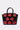 The STAY IN MY BAG PURSE has a structured silhouette in glossy faux leather, with seven small red handbags—each with a handle and gold clasp—arranged in two rows on the front of the large black bag.