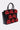 A structured, large black faux leather handbag with a glossy finish, decorated with several small red STAY IN MY BAG PURSE accessories featuring gold clasps and handles, is displayed on a plain light background.