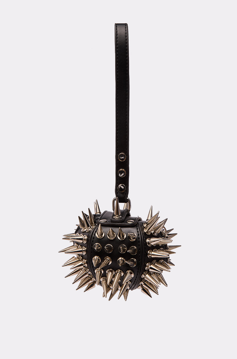 The IM SHARP MINI BAG is a small black circular faux leather mini bag featuring a wrist strap and adorned with long and short metallic spikes, displayed on a plain white background.