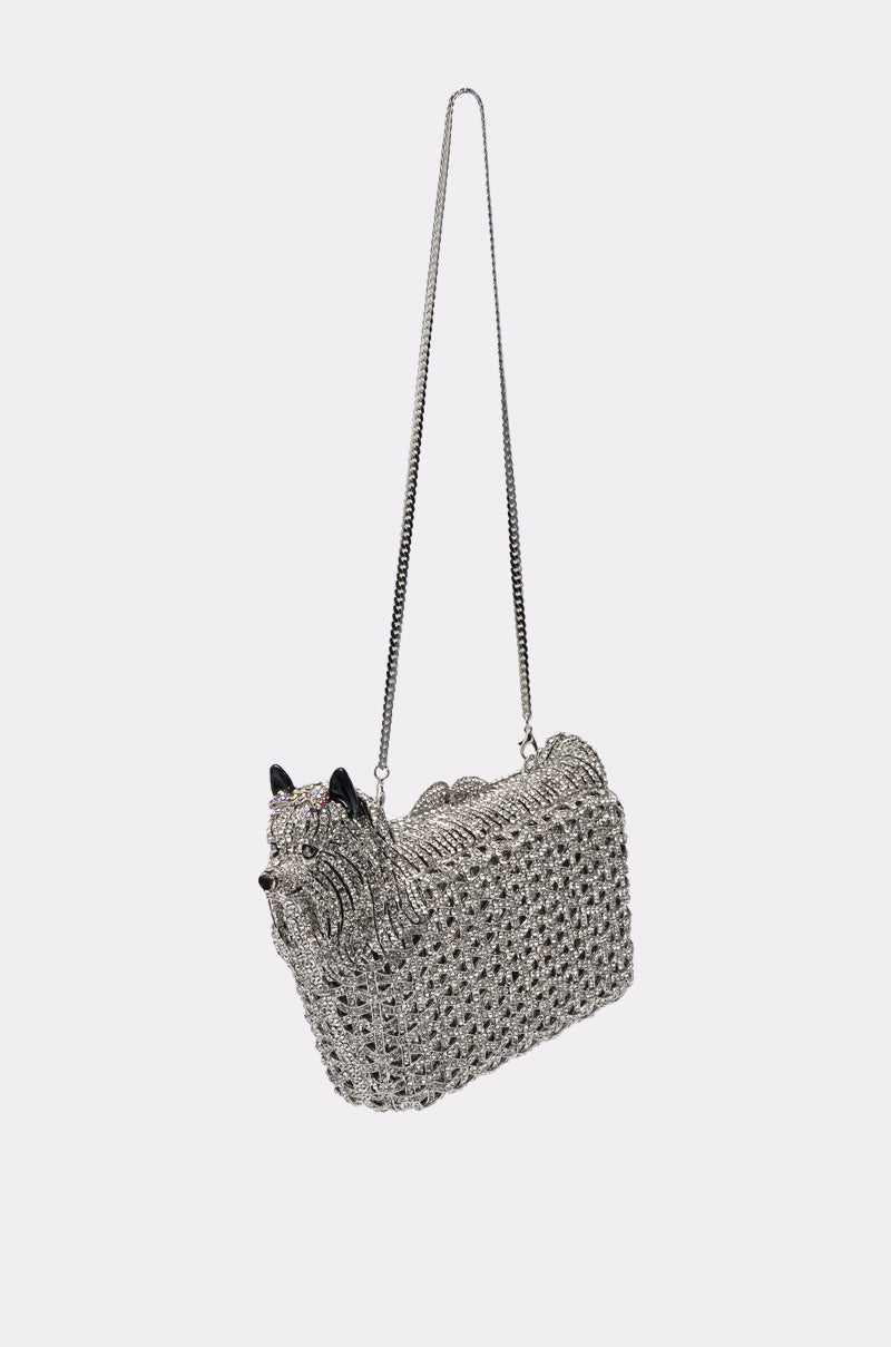 The CHARMAINE BLING PURSE is a silver, dog-shaped rhinestone bag with pointy black ears and a long chain strap, sparkling brilliantly against a plain white background.
