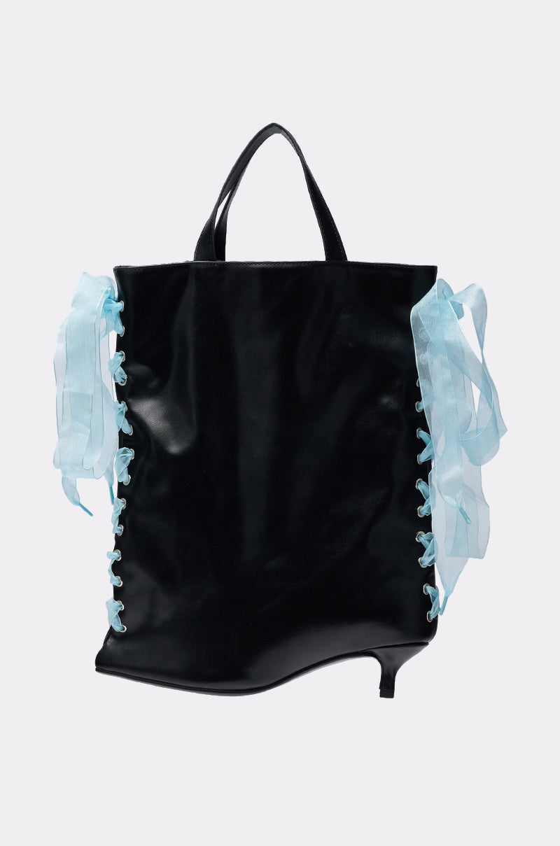 The TIE MY SHOE PURSE is a black tote bag in glossy vegan leather with top handles, light blue ribbon laces on the sides, and a playful high-heeled shoe-shaped corner for a fun kitten heel handbag look. 0