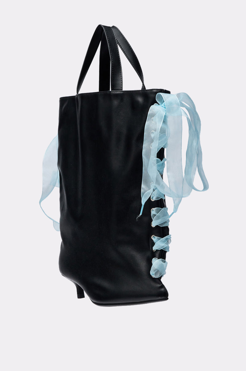 The TIE MY SHOE PURSE is a black vegan leather bag with two handles and a light blue sheer ribbon laced through eyelets and tied in a bow on one side—a unique accessory for any outfit. 2